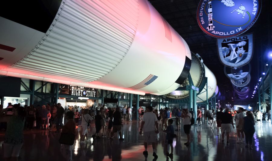 You are in a Great Hall, beneath the Saturn V. It does not seem real. Even when you are looking directly at it from close range. But it is. It is real. And what it did was real, too.